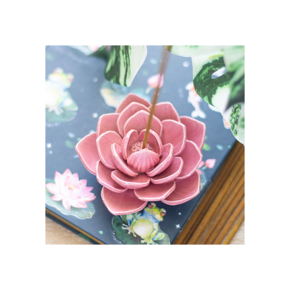 Pink flower-shaped incense burner on a decorative card with floral design